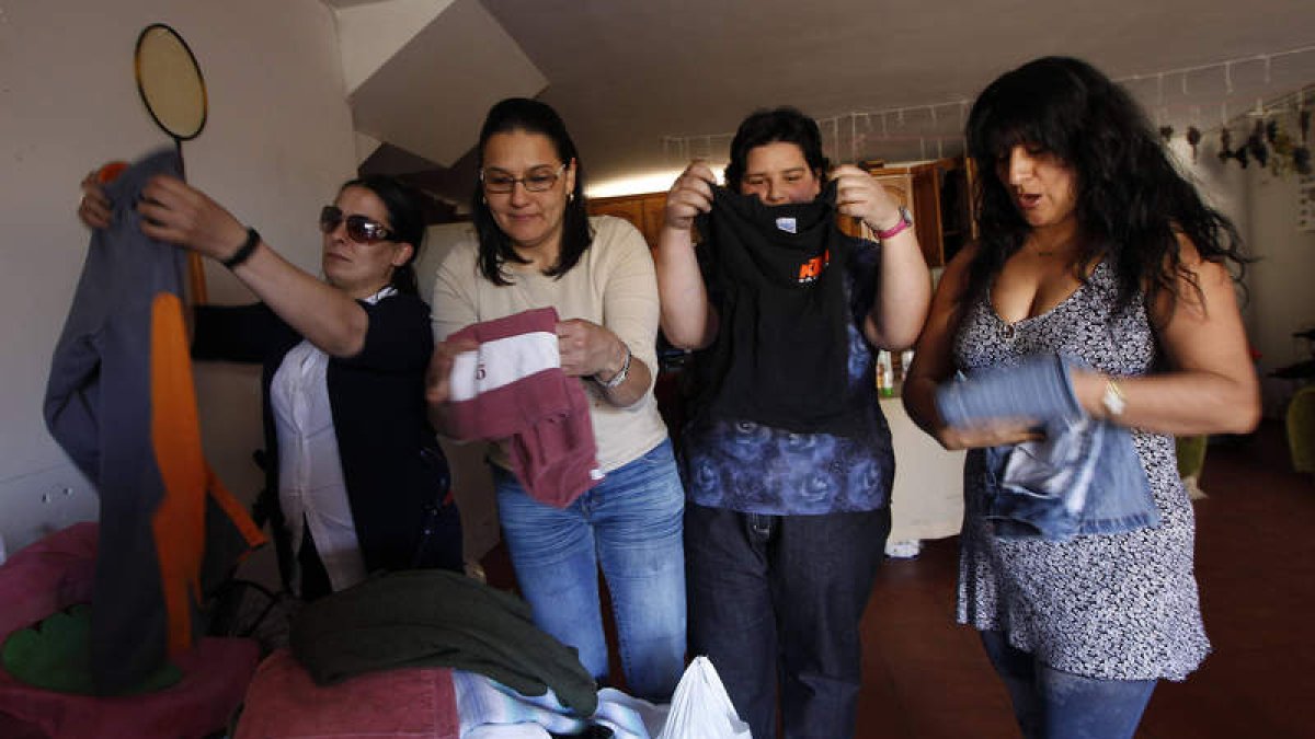 Cuatro de las Mujeres Anticrisis doblan las prendas cedidas al ropero.