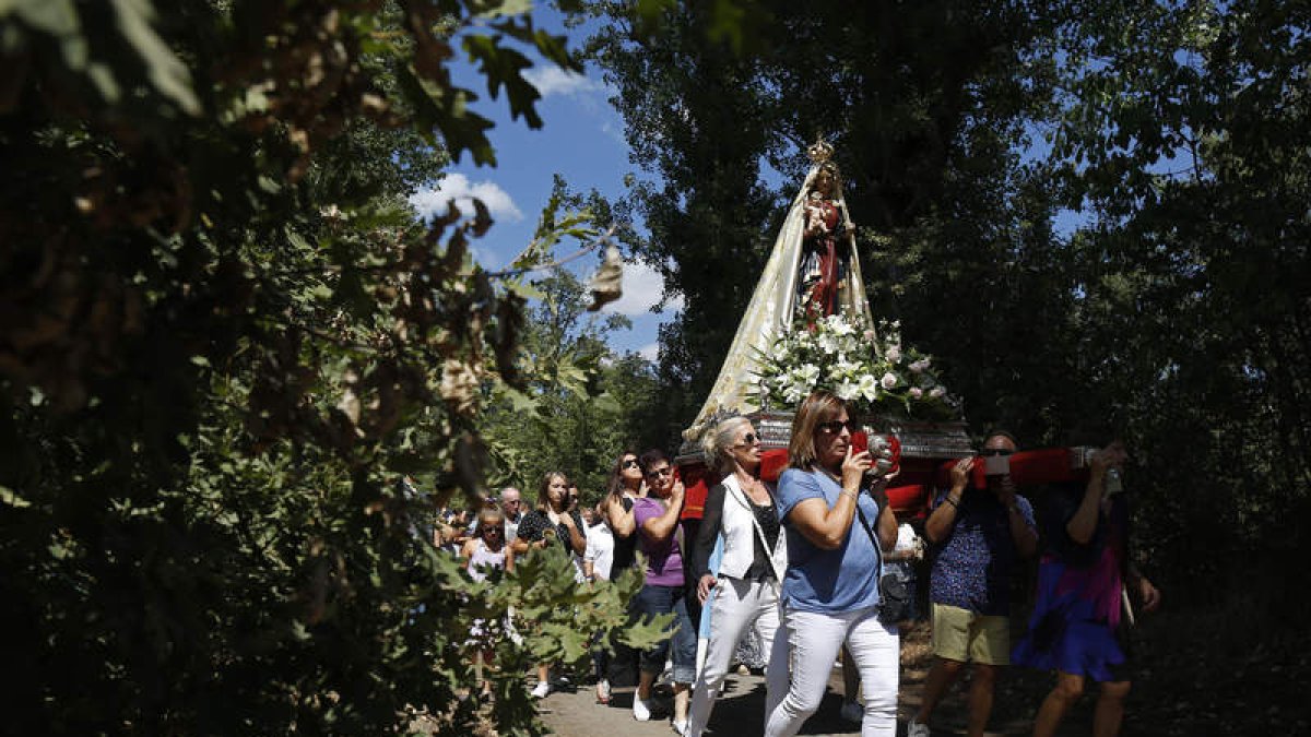 La procesión discurre entre los árboles que crecen a orillas del río Torío.. FERNANDO OTERO