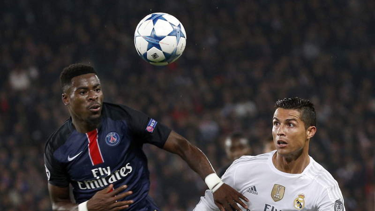 El delantero del Real Madrid, Cristiano Ronaldo, pelea por el control del balón con el jugador del París Saint Germain, Serge Aurier