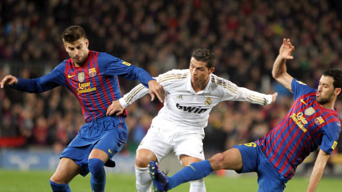 Piqué y Sergio Busquets presionan al portugués Cristiano Ronaldo, del Real Madrid, durante el partido de vuelta de los cuartos de final de la Copa del Rey.