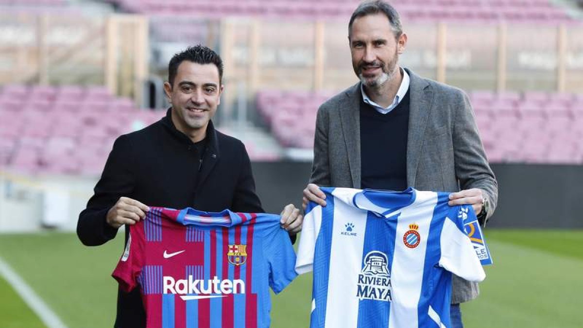 Xavi Hernández y Vicente Moreno posan con las camisetas del Barça y el Espanyol. ALEJANDRO GARCIA