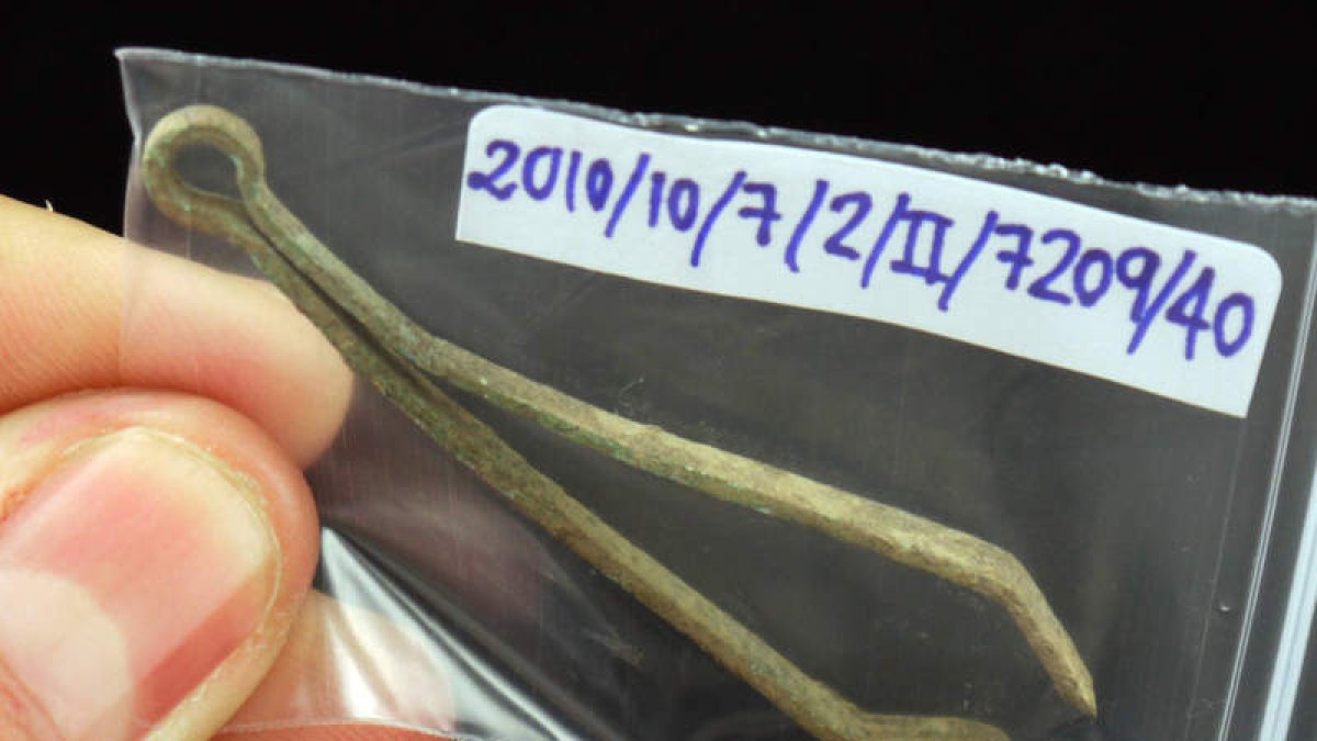 Unas pinzas de depilar y colección de agujas de hueso y otros útiles para las artesanías textiles.