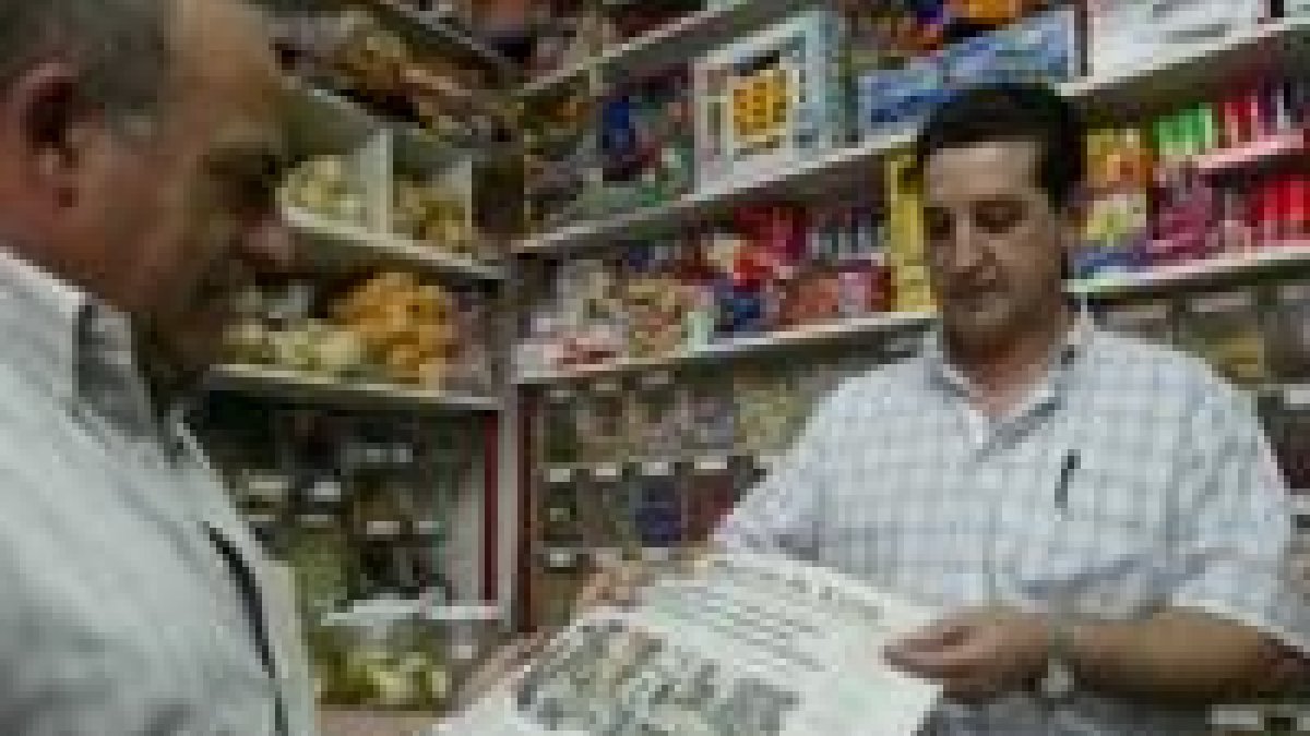 Un lector del Diario de León compra el periódico en un quiosco de la capital