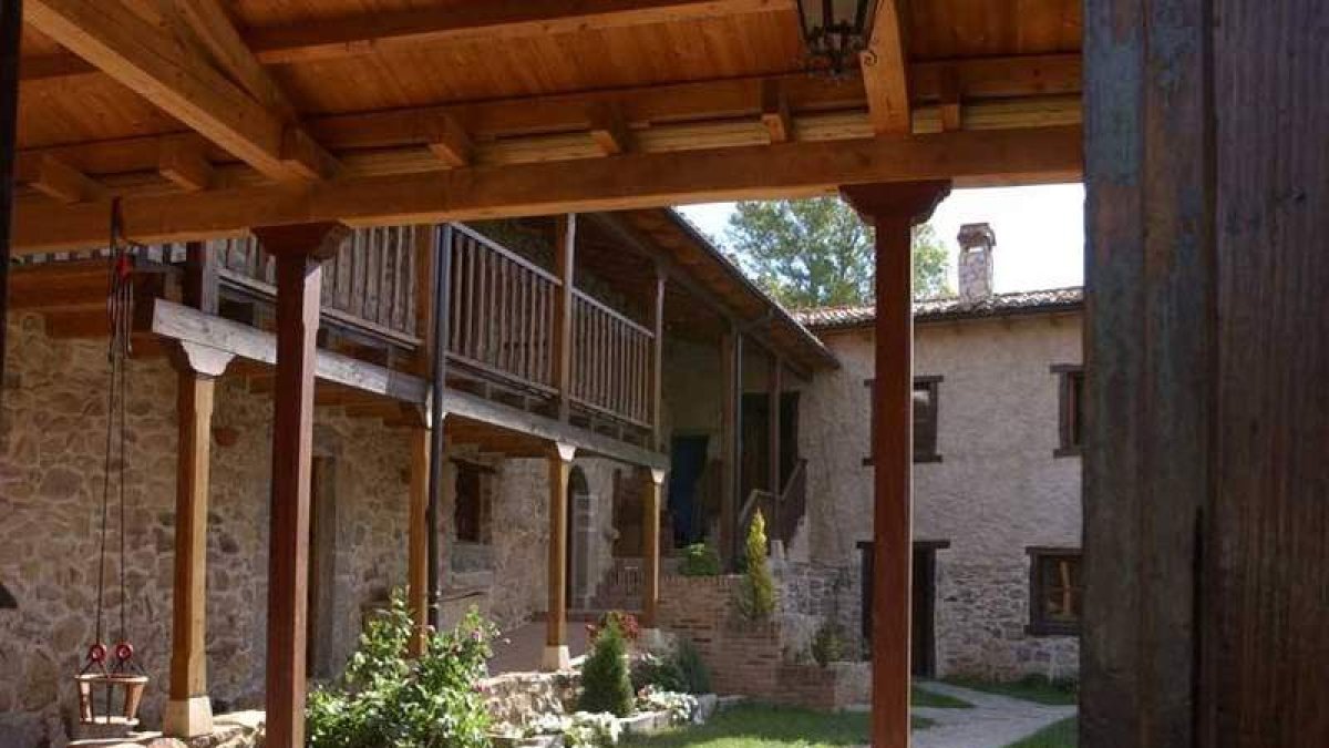 Patio interior y uno de los dormitorios de las Casas de Valdepiélago.