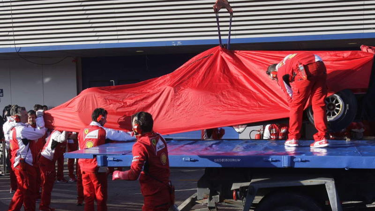 El F14T de Raikkonen es izado sobre un camión grúa tras una avería en el primer día de ensayos.