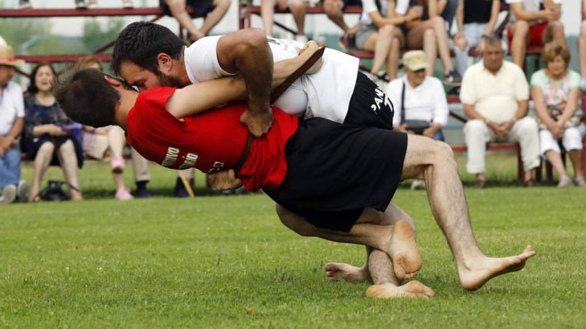 Víctor Llamazares y Alejandro Franco durante el corro celebrado en Villaquilambre dentro de la Liga de Verano de lucha leonesa. MARCIANO PÉREZ