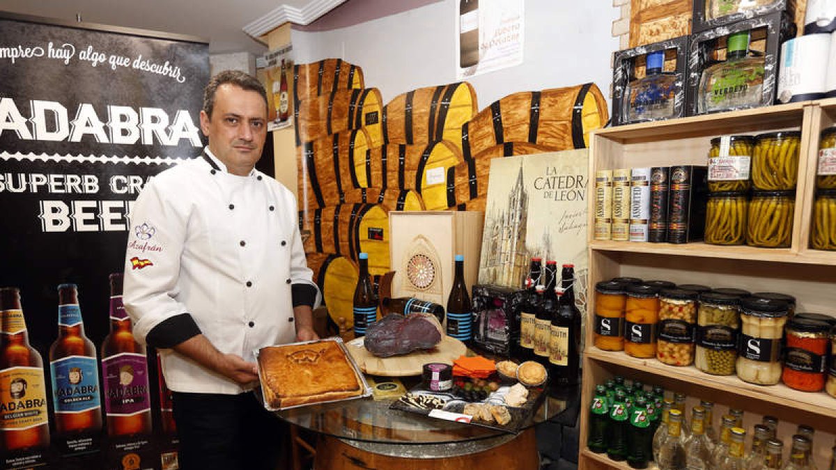 El propietario de Azafrán, Eugenio Guerra, junto a varios de los productos gourmet que pueden encontrarse en su tienda, en el número 15 de la calle Villabenavente, en el centro de León.