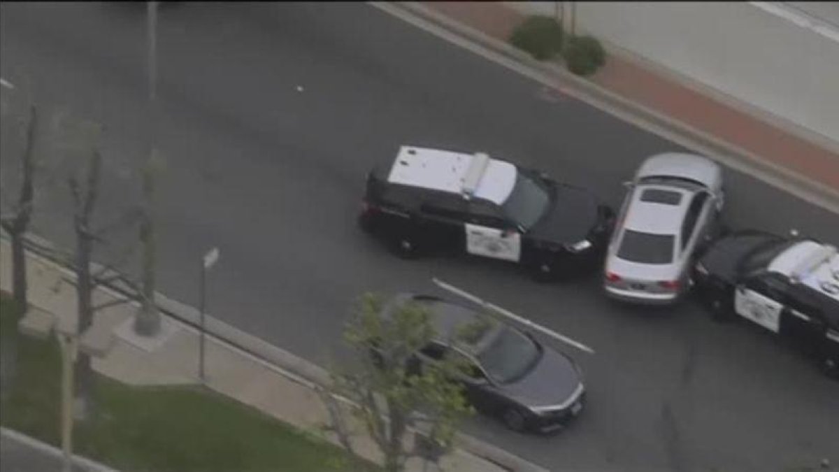 Parecía que dos coches de policía habían acorralado al ladrón de un vehículo cuando consigue escapar conduciendo de un lado a otro de la carretera.