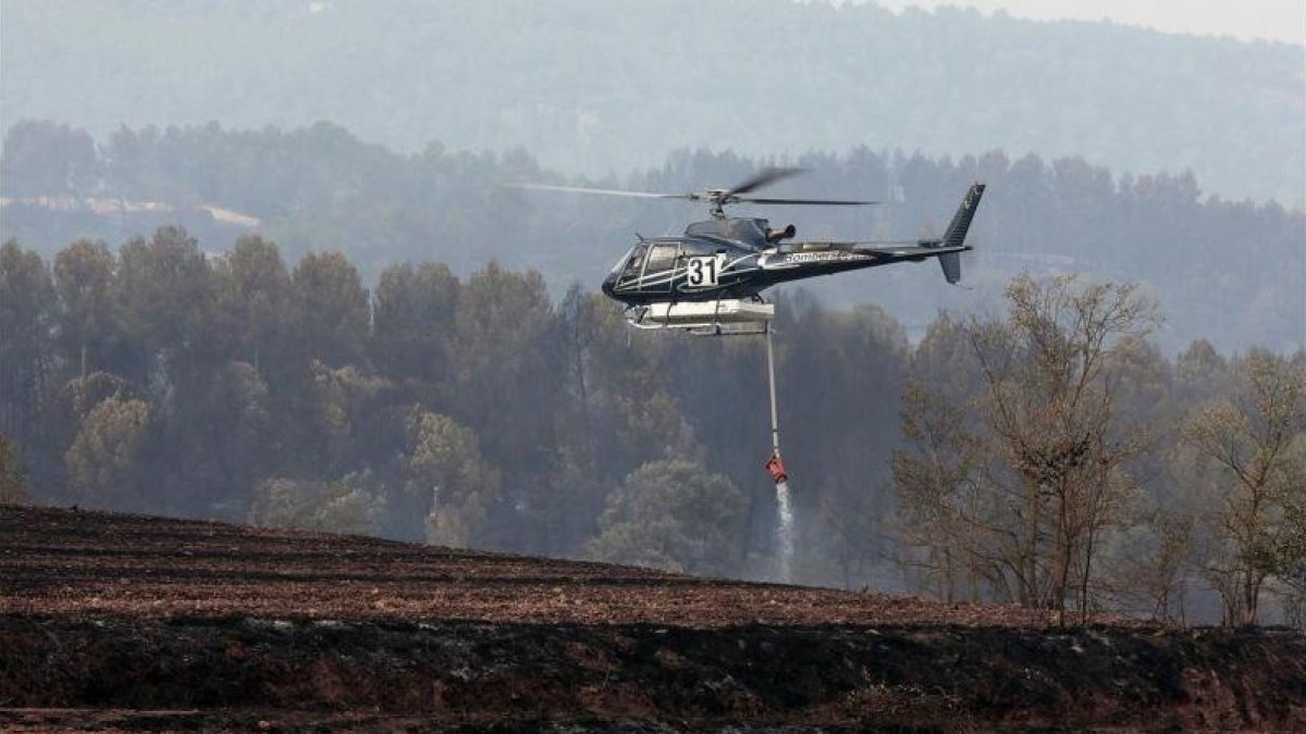 Un helicóptero trabaja en las labores de extinción del incendio forestal de Artés.