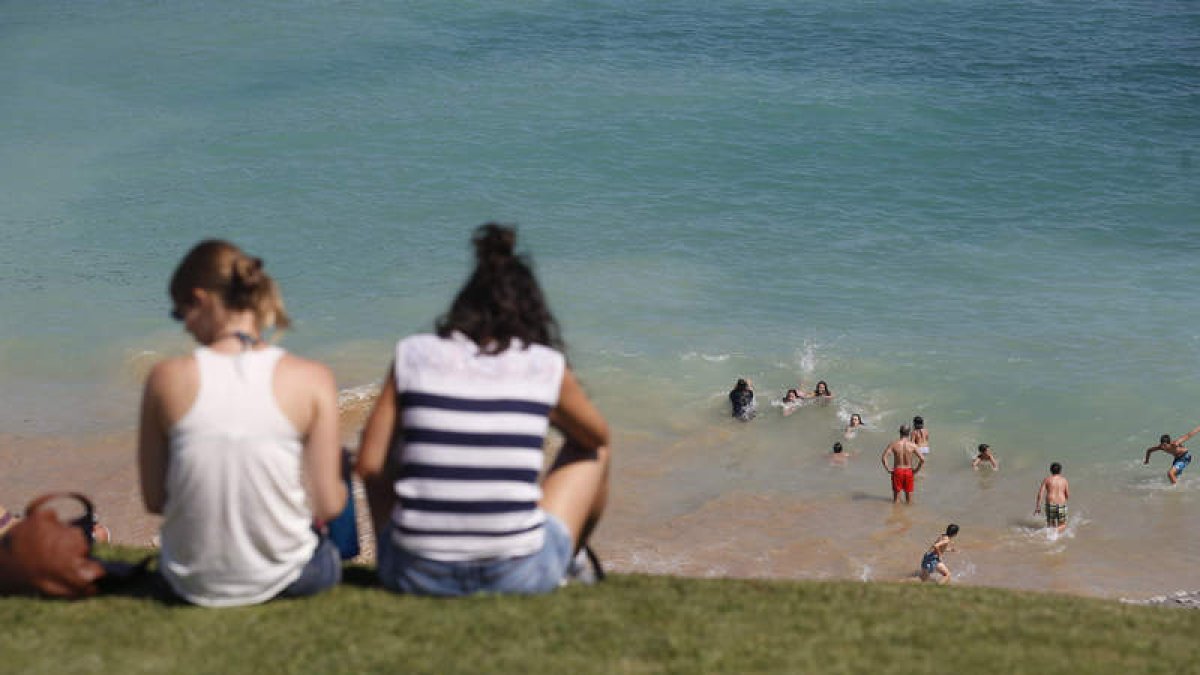 Unos jóvenes se bañan en la playa, ayer en Ondarreta, San Sebastián. JUAN HERRERO