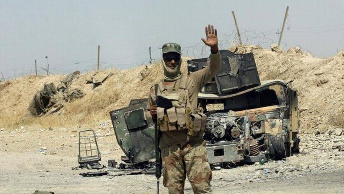 Un soldado iraquí posa ante un vehículo blindado destruido perteneciente al Estado Islámico cerca de Amerli (Irak).