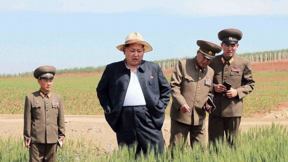 Kim Jong-un en una inusual imagen con su chaqueta abierta durante la visita a una granja.