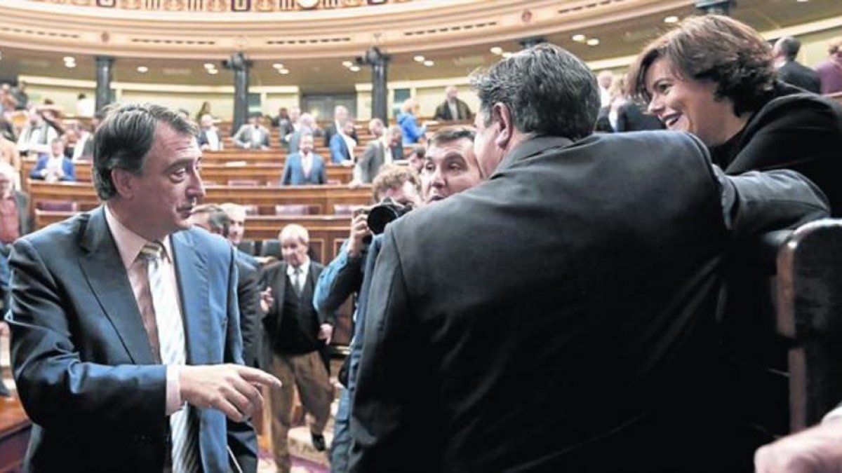 El diputado del PNV Aitor Esteban (izquierda) saluda a Soraya Sáenz de Santamaría, en un pleno del Congreso.