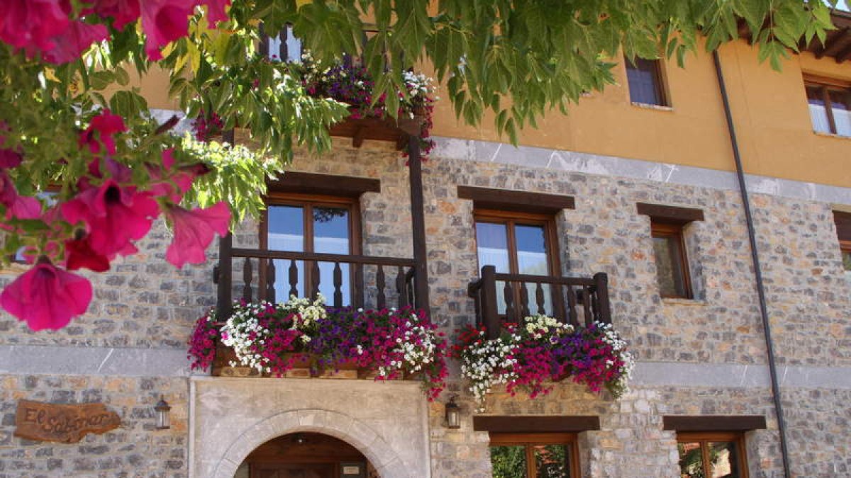 Fachada y una de las estancias del Centro de Turismo Rural El Sabinar, en Crémenes.