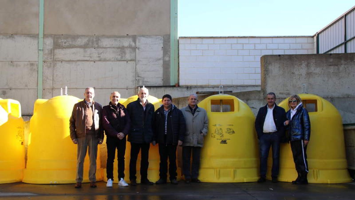 Miembros de la junta directiva de Mansurle posan con los nuevos contenedores para envases. DL
