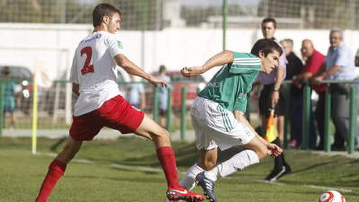 El jugador del Astorga Mario Villar intenta zafarse del marcaje del lateral del Santa Marta Oli.