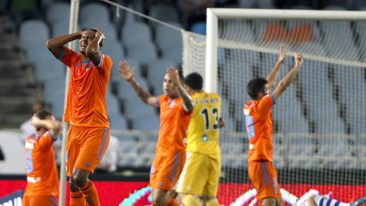 Los jugadores del Valencia se lamentan de una ocasión fallada.