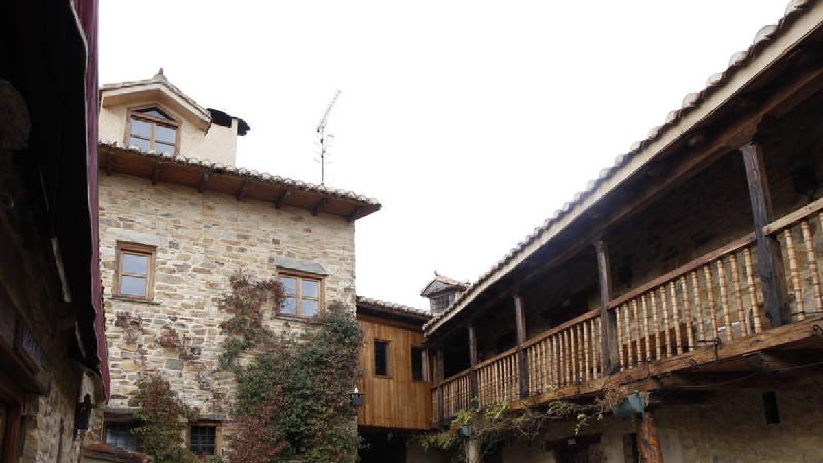 El tradicional patio maragato y una de las habitaciones con mantasdel Val enCasa Pepa, en Santa Colomba de Somoza.