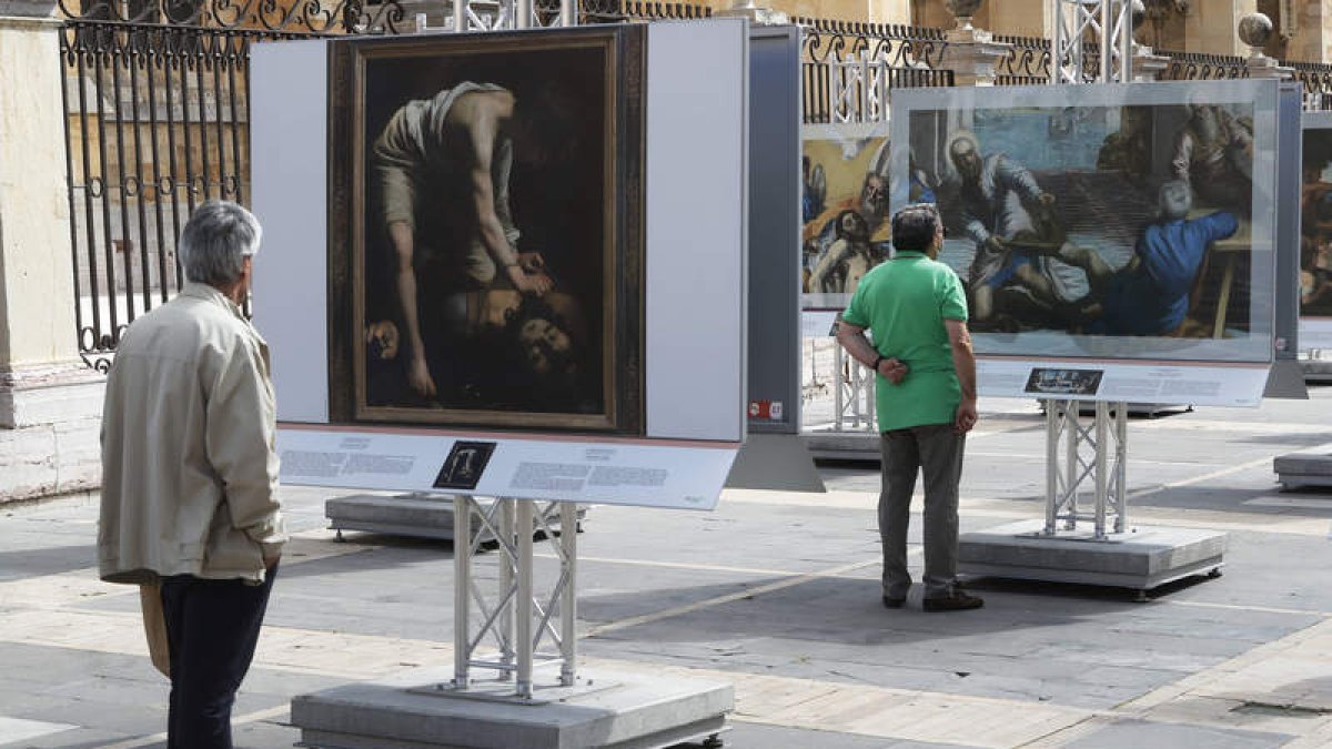 Imágenes de los primeros visitantes de la exposición ‘El Museo del Prado en las calles’, instalada en la plaza de Regla, en la fachada sur de la Catedra. RAMIRO