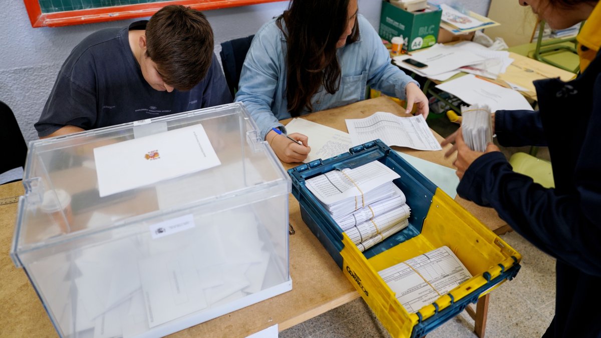 Una empleada de Correos entrega votos por correo en una de las mesas de un colegio electoral. NACHO GALLEGO