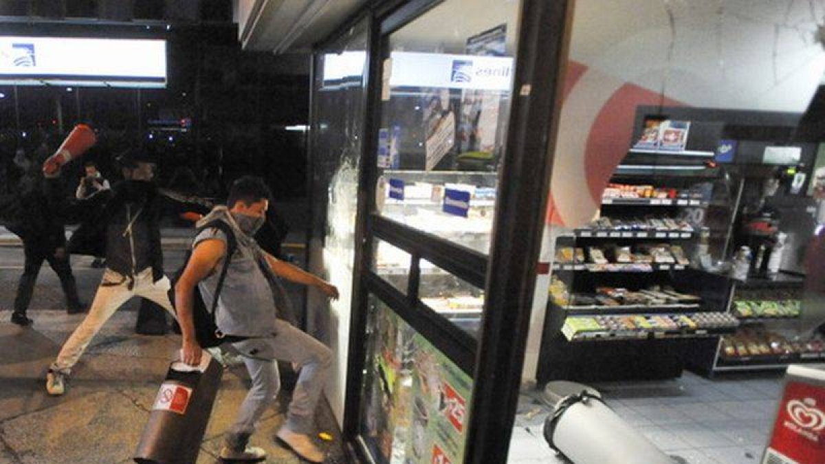 Manifestantes asaltan un comercio, en el paseo de la Reforma de Ciudad de México, ayer.