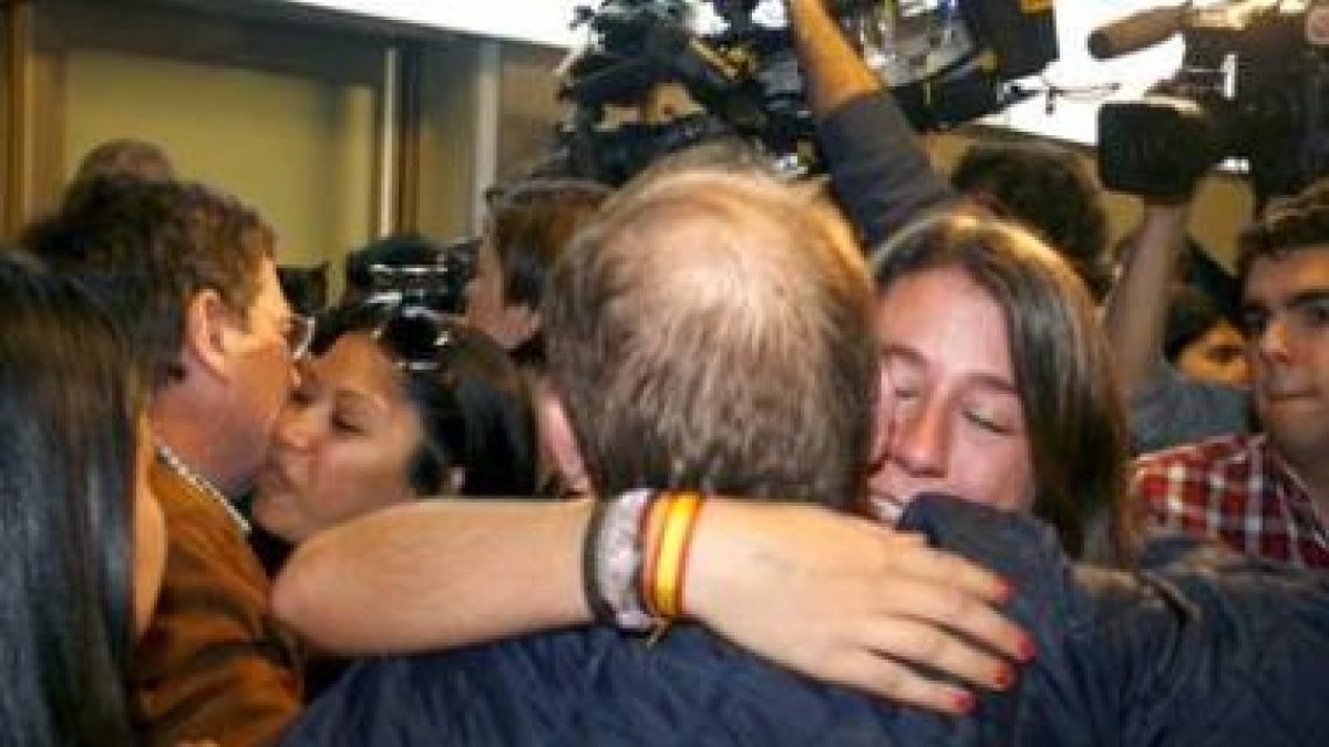 Una mujer abraza a un familiar al llegar, ayer, a Barajas tras aterrizar el avión de Repsol.
