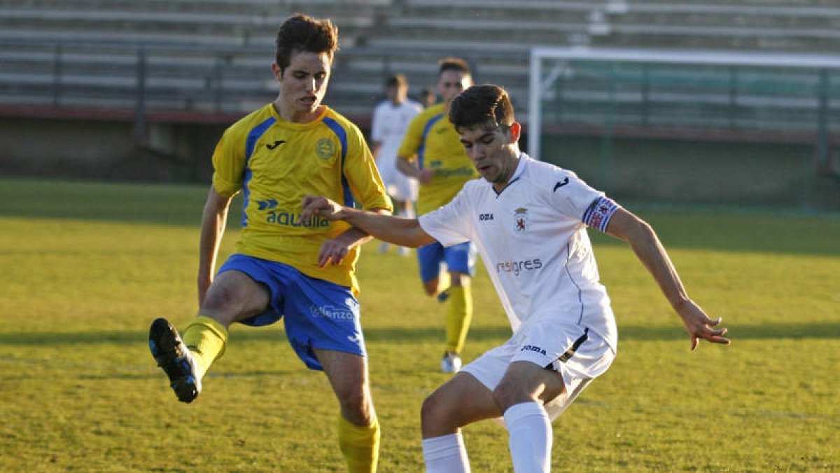 Celada, a la derecha, controla el balón ante la oposición de un jugador abulense. F. OTERO PERANDONES