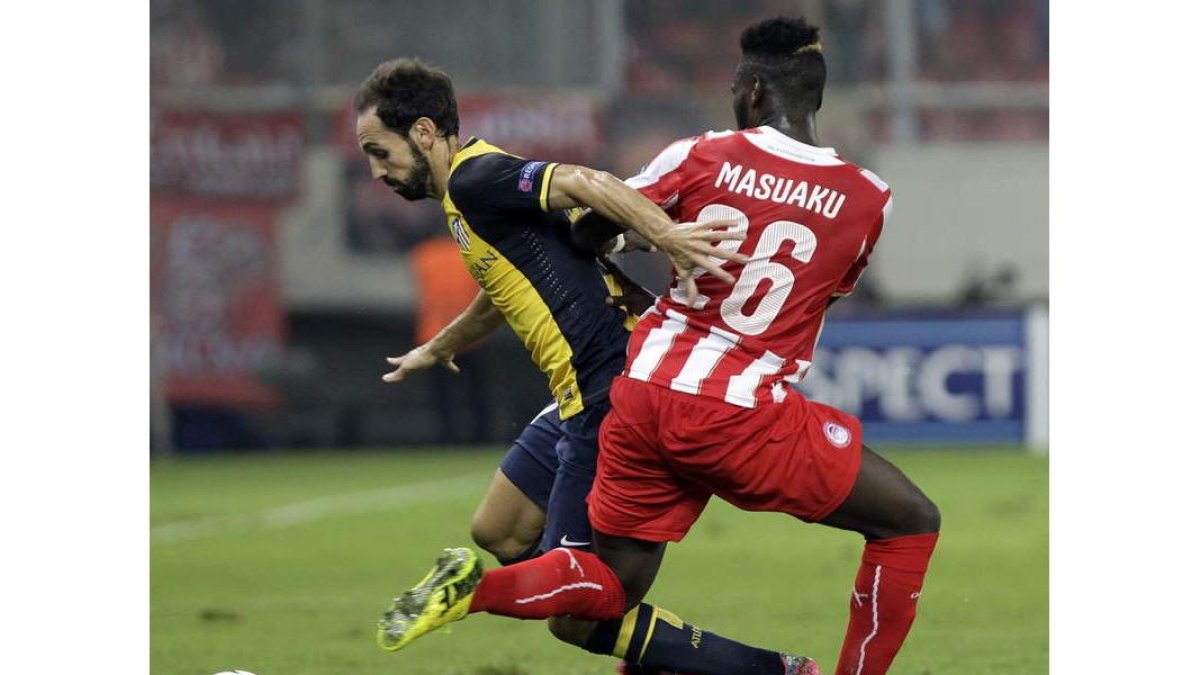 El jugador del Olympiacos Arthur Masuaku lucha por el balón con el atlético Juanfran.