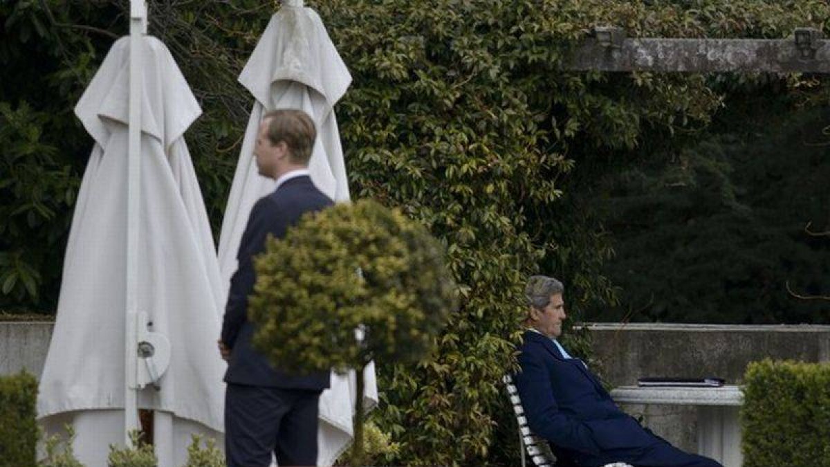 El secretario de Estado de EEUU, John Kerry (sentado), durante un receso en las negociaciones.