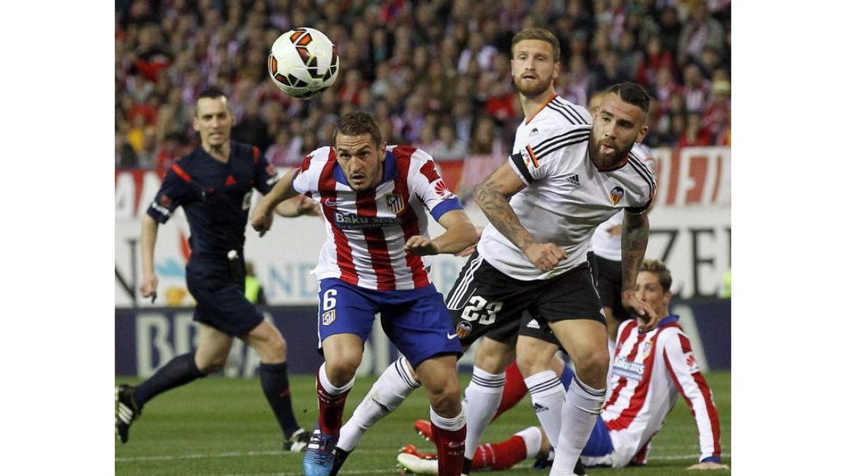 El jugador del Atlético, Koke, autor del gol rojiblanco, trata de escapar de Otamendi