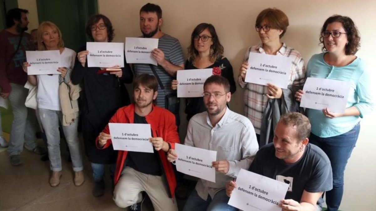 Diputados de la CUP y de Podem en Barberà del Vallès con carteles a favor de la democracia y del referéndum.