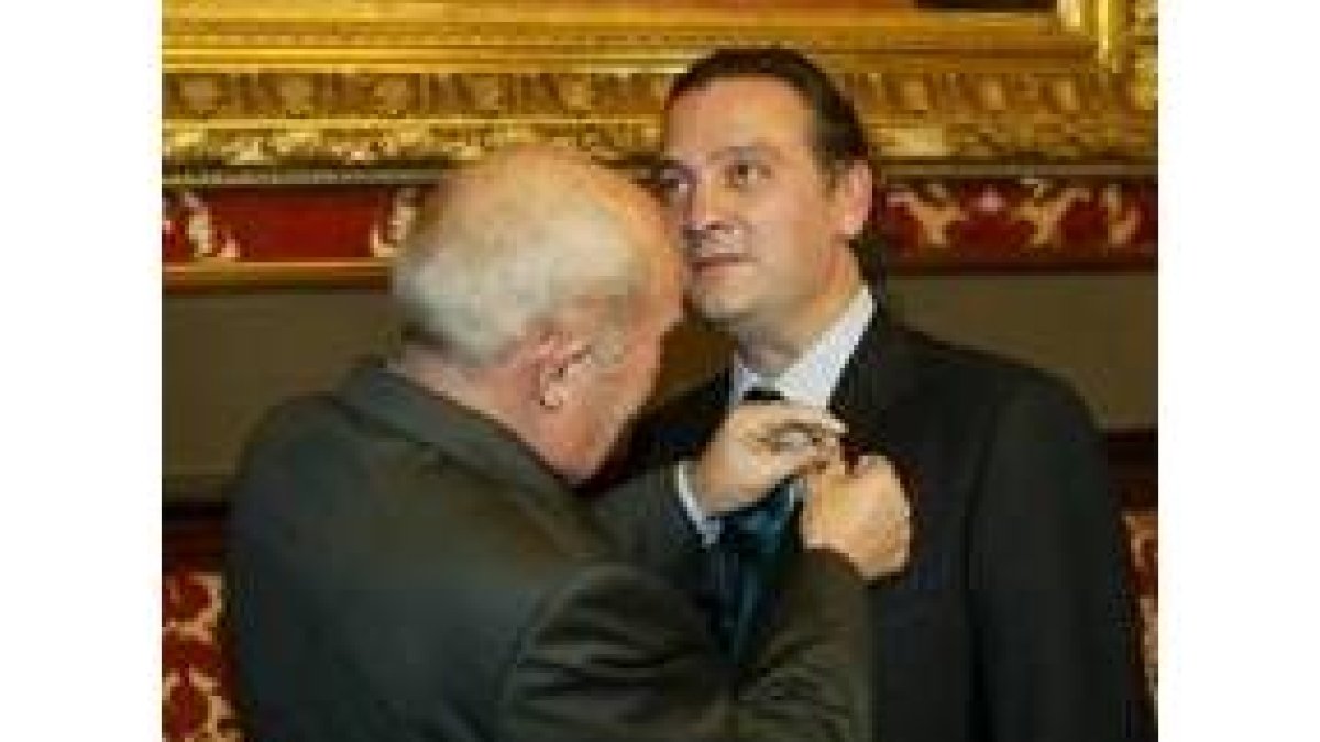 Momento en el que Antonio García de Celis impone la insignia a Prada