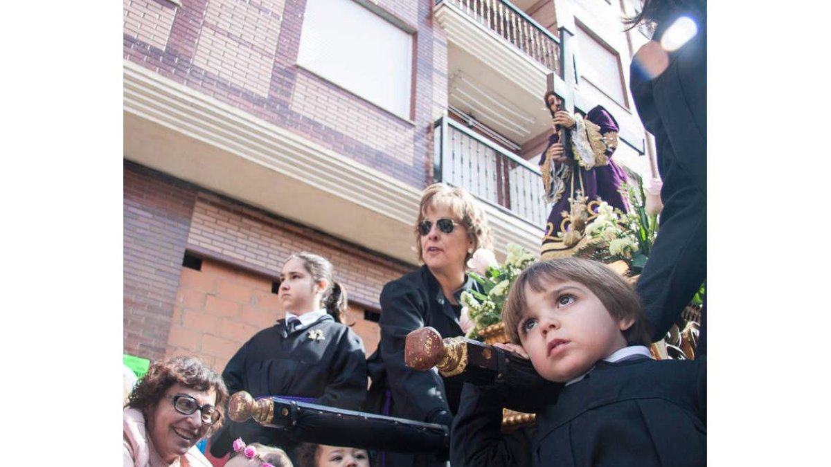 Los niños pujan con fervor al Potajerín de Las Angustias, una procesión que ayer reunió a las autoridades civiles y eclesiásticas en La Bañeza. FERNANDO OTERO PERANDONES