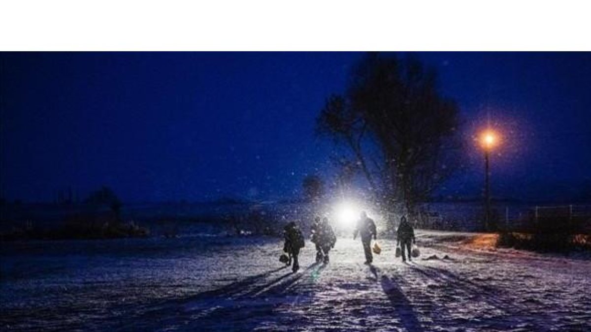 Un grupo de refugiados caminan de noche entre la nieve cerca de la localidad serbia de Miratovac.