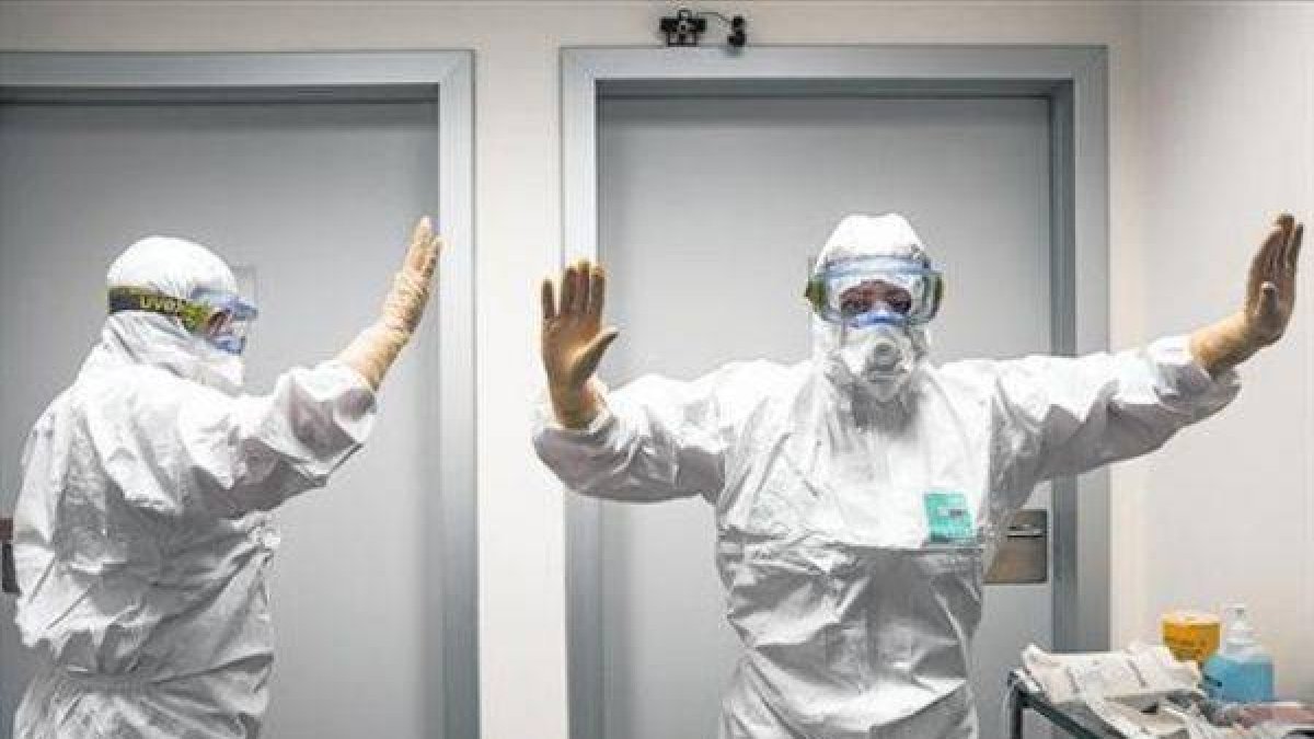 Sanitarios de Valencia reciben indicaciones sobre el modo de colocarse los trajes para tratar el ébola.