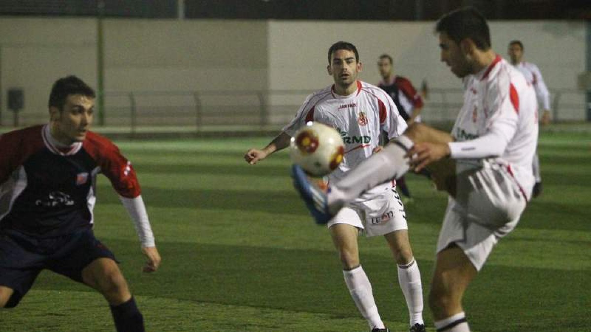 Viti controla el balón ante la oposición de Rubén, centrocampista del Atlético Astorga y de la selección autonómica.