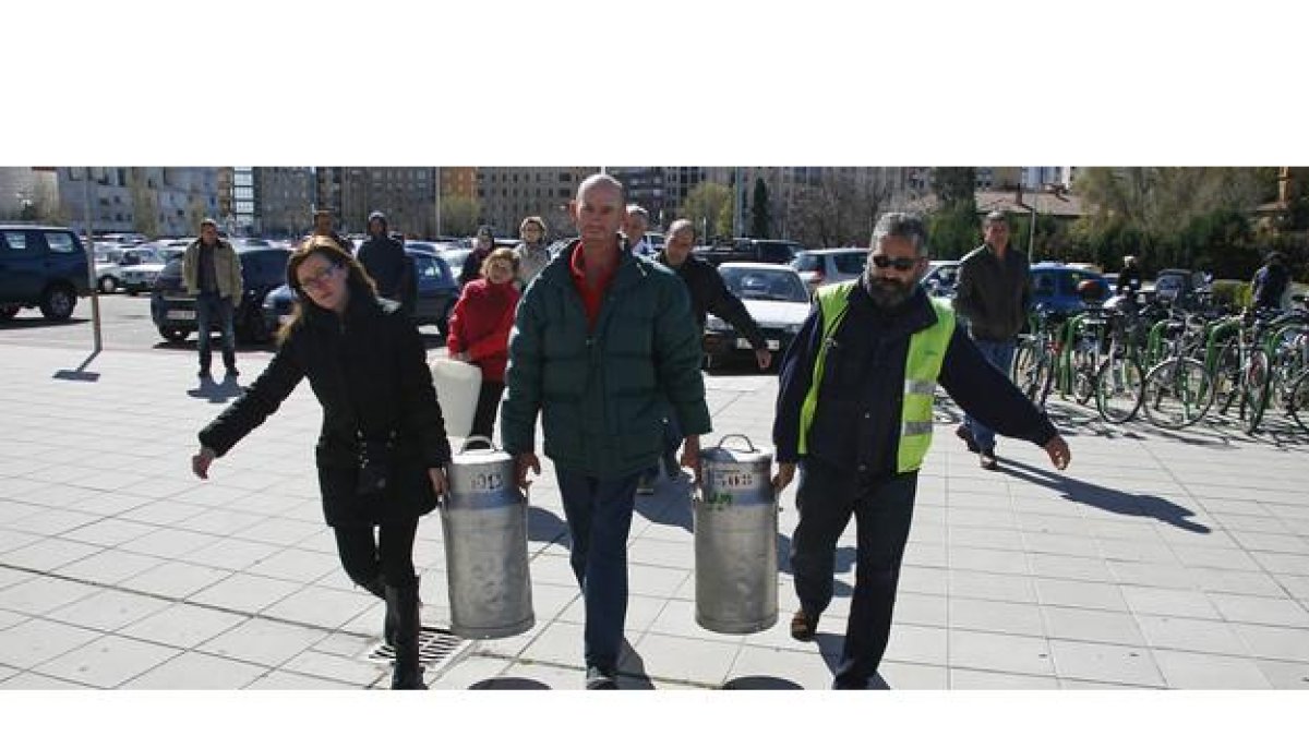 Ganaderos leonesas llevan cántaros de leche ante el edificio de la Junta en León en protesta por la crisis del sector