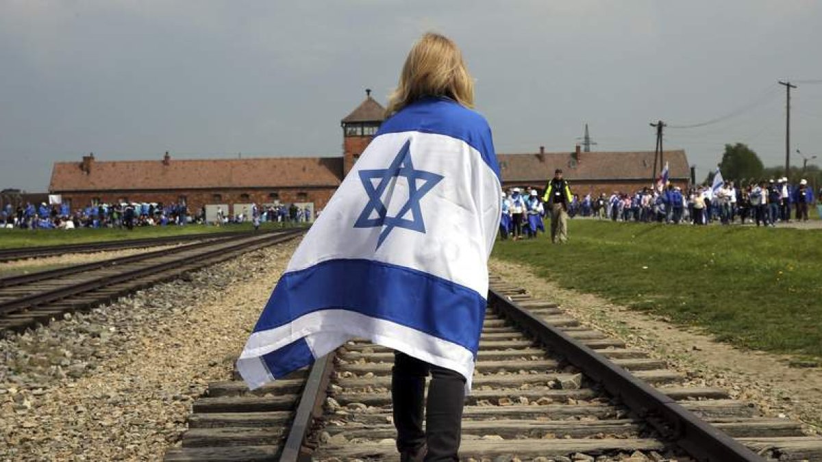 Una mujer camina junto a las vías del tren que lleva a Auschwitz durante la tradicional «Marcha de los vivos».