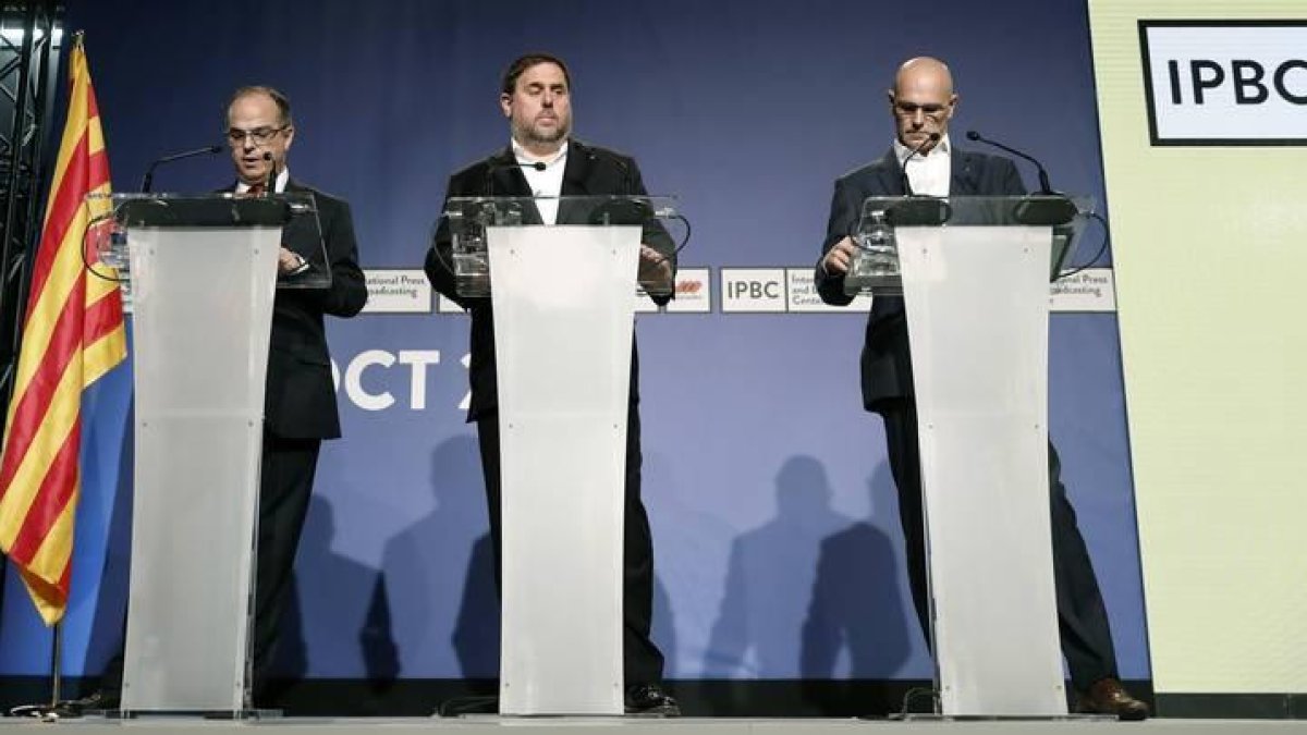 El vicepresidente de la Generalitat, Oriol Junqueras (c); el conseller de la Presidencia, Jordi Turull (i), y el conseller de Asuntos Exteriores, Raül Romeva, durante la rueda de prensa de hoy por la que se pagaron 10 euros.