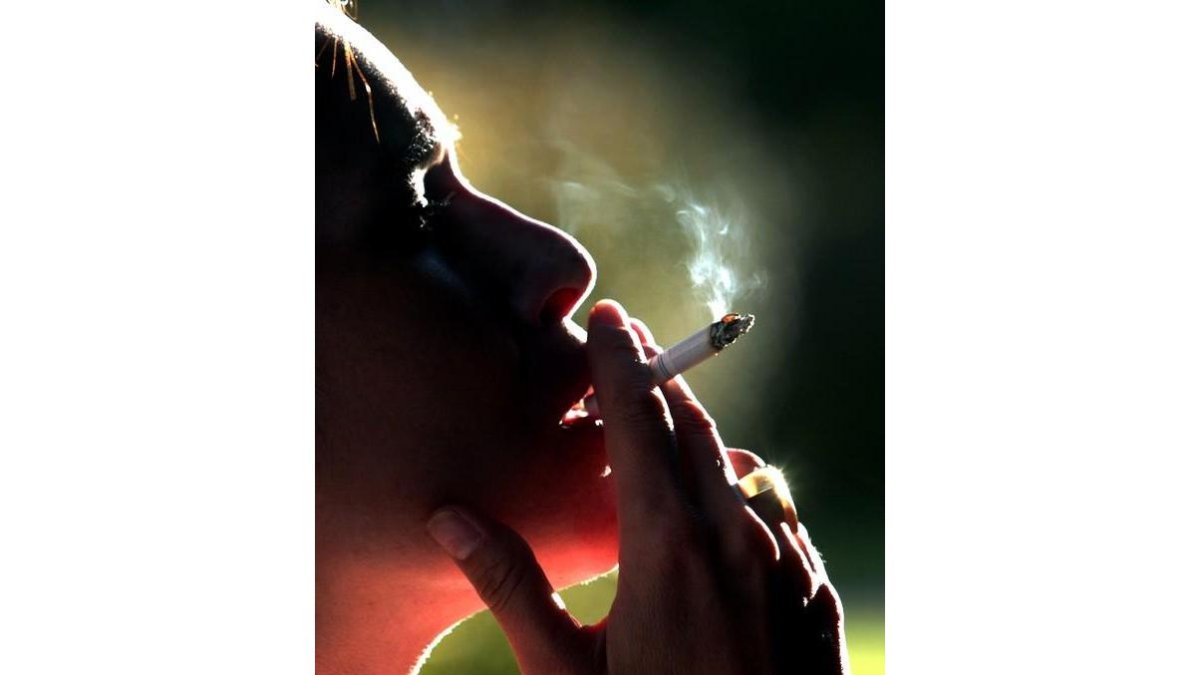 Una mujer fuma un cigarrillo. Imagen de archivo