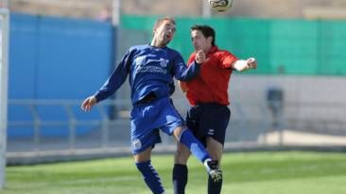 Fontanillo, a la izquierda, despeja un balón a pesar del acoso de un jugador del conjunto soriano