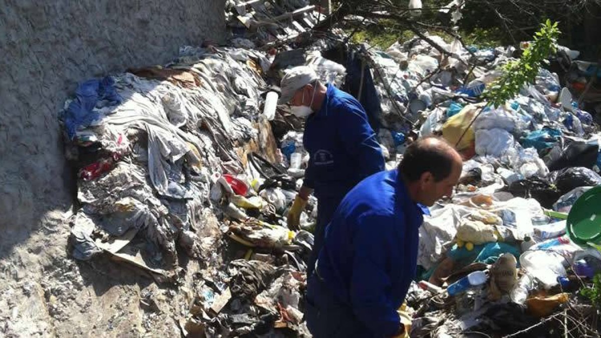 Operarios municipales, el pasado viernes, en el exterior de la vivienda de Castroquilame.