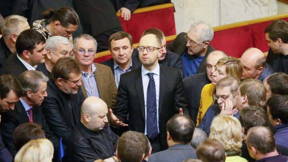 El líder de la oposición ucraniana, Arseniy Yatsenyuk (c-arriba), habla con miembros de su fracción durante una sesión extraordinaria del Parlamento ucraniano.