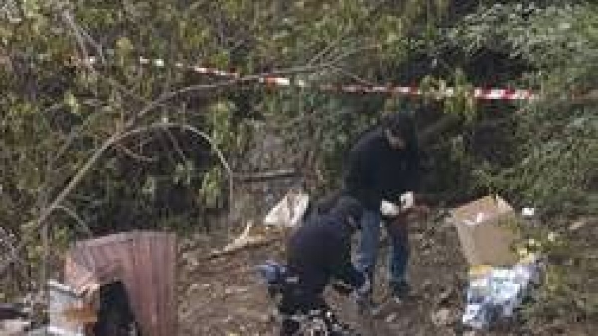 Agentes de la policía científica inspeccionan el lugar del incendio