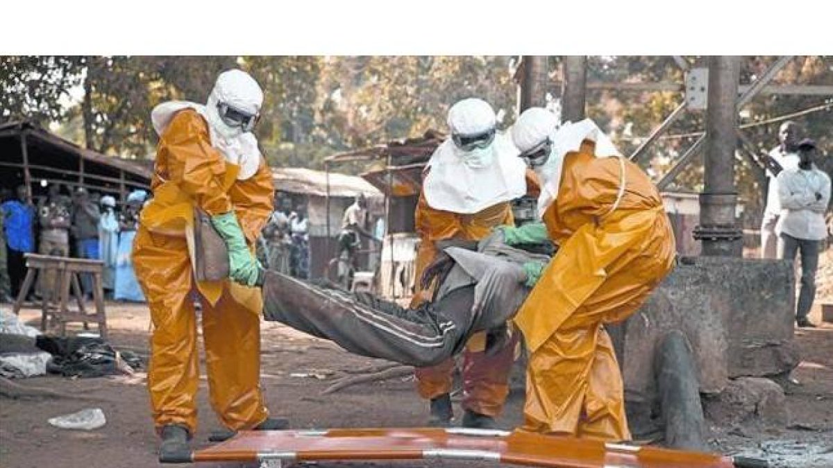 Sanitarios de la OMS retiran el cadáver de un enfermo de ébola en Guinea, el pasado enero.