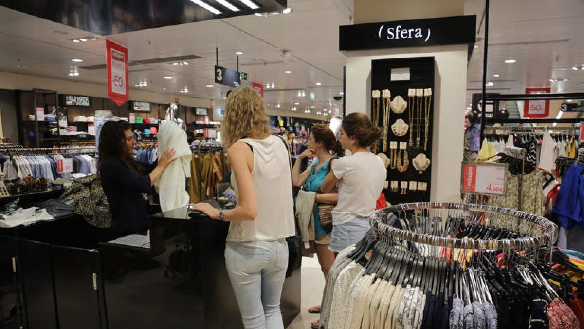 Clientes en El Corte Inglés, ayer. En la otra imagen, exterior de Violeta, en el centro.  SECUNDINO PÉREZ