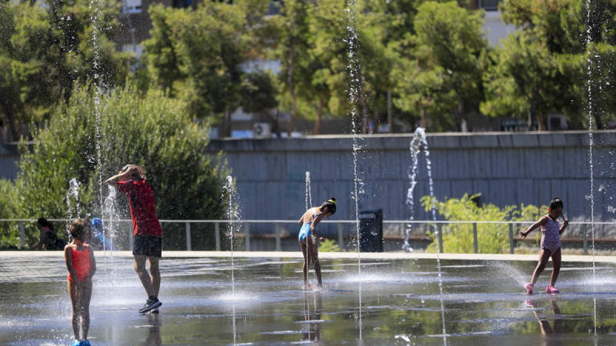 Varias personas se refrescan en la zona de Madrid Río. FERNANDO ALVARADO
