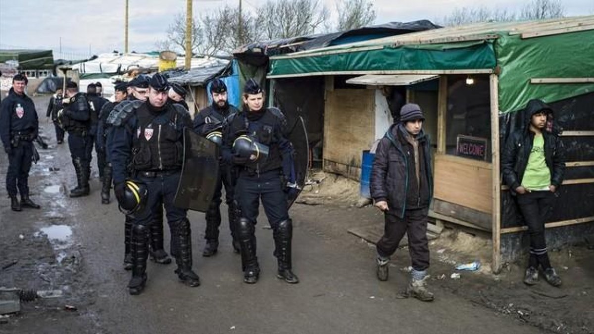 Agentes de seguridad patrullan el campamento conocido como 'La jungla' en Calais que fue desmantelado.