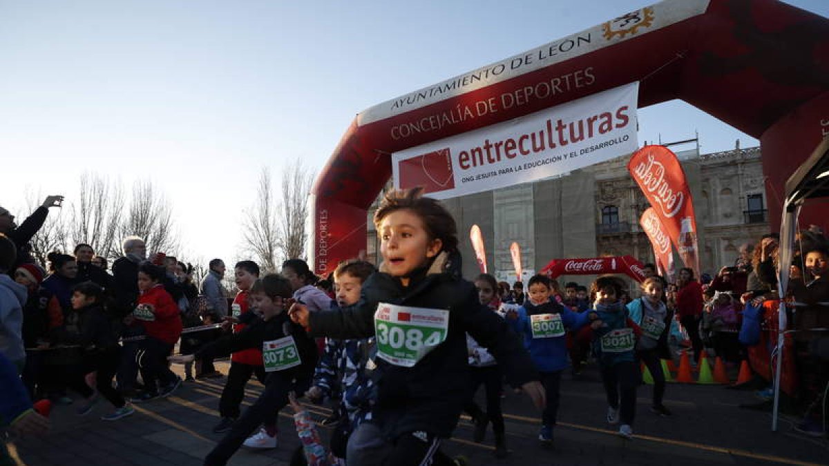 Niños y niñas en la meta de salida de la carrera nocturna de Entreculturas en León.