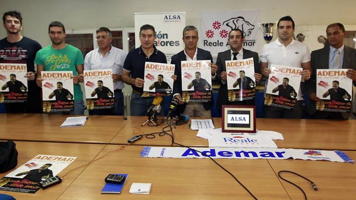 Manolo Cadenas, en el centro, junto al vicepresidente del Ademar, Boni Álvarez, y a varios jugadores del primer equipo.